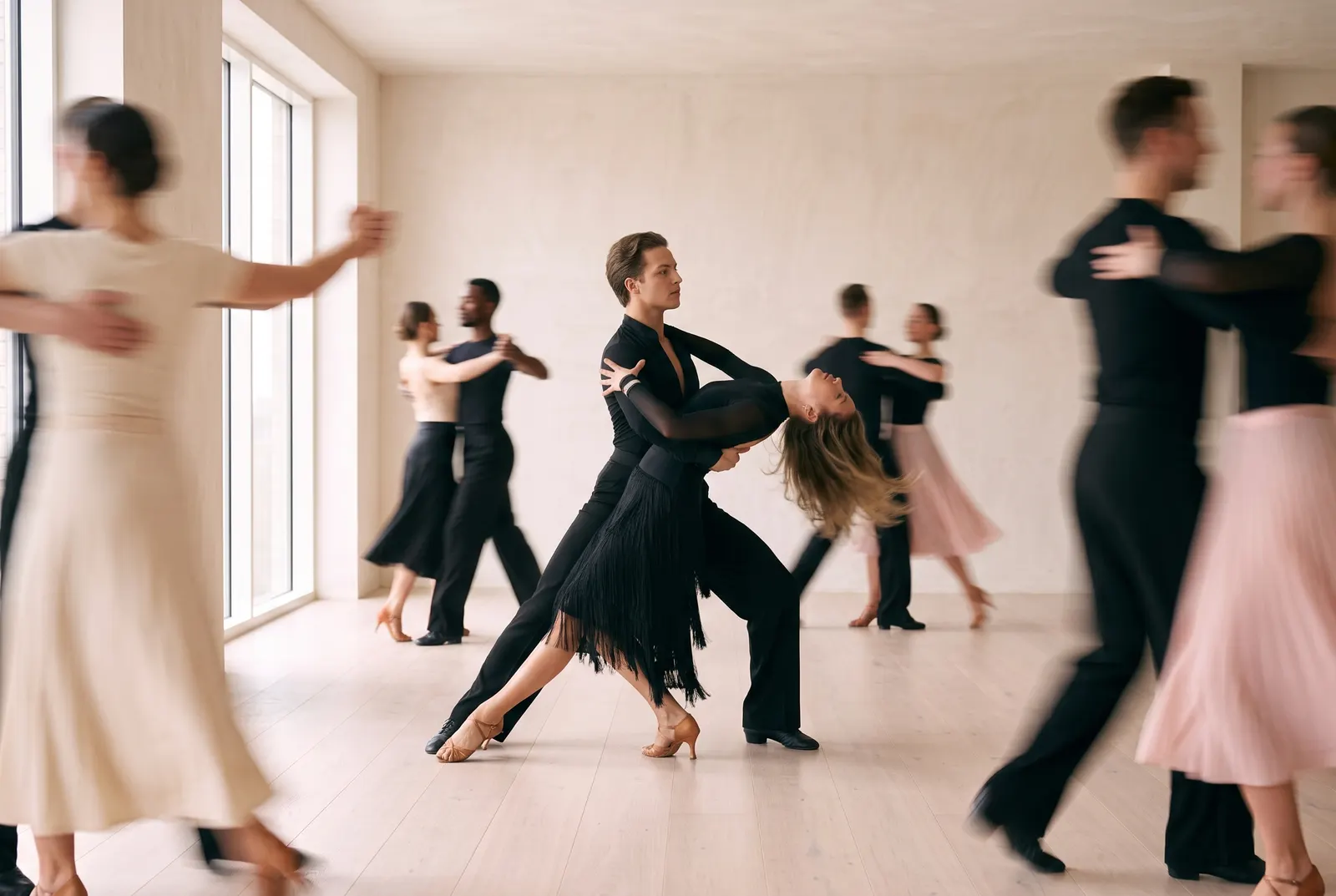 A couple held in a deep oversway in the middle of the room, other dancers moving past them.